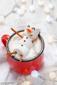 Red mug with hot chocolate with melted marshmallow snowman